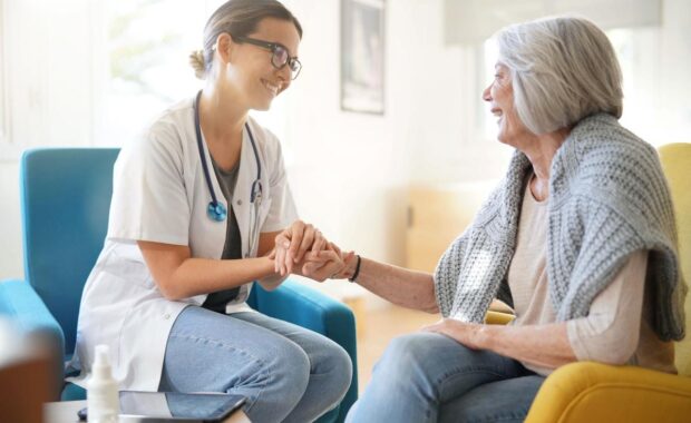 Doctor reassuring older woman in modern clinic