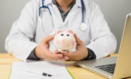health care physician holding a piggy bank to show affordable health concept
