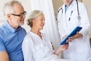elderly couple discussing with a doctor and a Fairfax, VA benefits consultant about potentially switching to a direct primary care plan