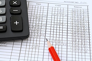 a pencil paper and calculator being used by a business consulting firm as they are calculating sellers discretionary earnings during a business valuation