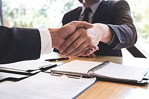 a business consulting firm shaking hands with a business owner during their business valuation meeting