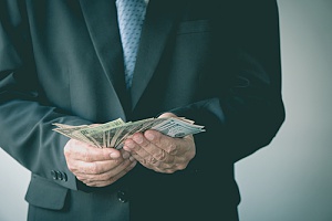 a business owner holding money which represents self funding