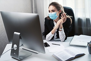 an employee working in her office with a mask
