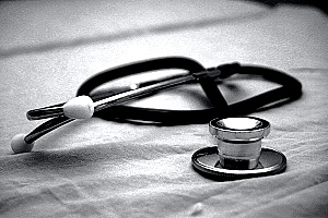 a stethoscope on a gray background representing medical care