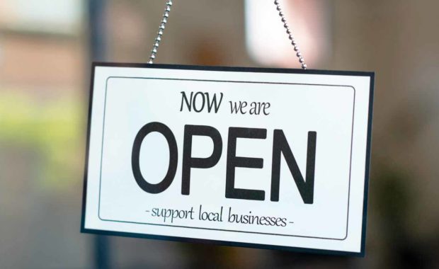 a-support-local-business-sign-with-the-words-now-we-are-open-after-addressing-employee-safety