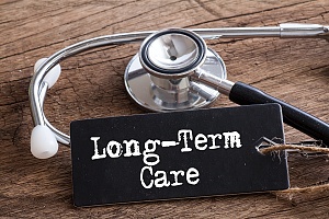 the words long term care with a stethoscope on a wooden table