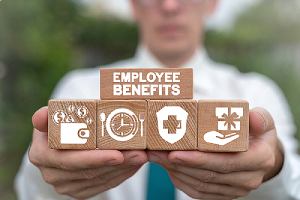 A person holding wooden cubes that has employee benefits icons. Benefits renewal can be a complex topic