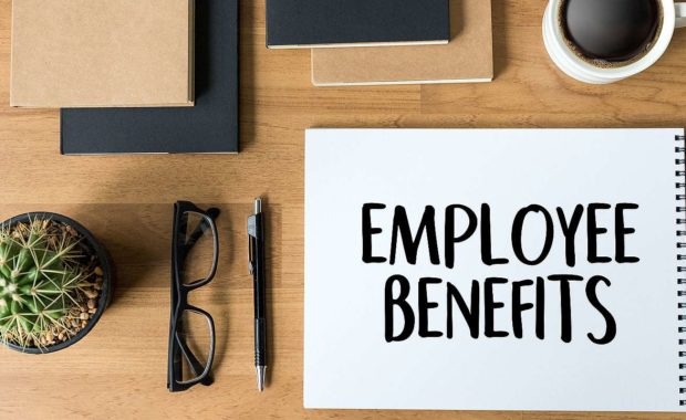 Employee benefits written on a notepad. Businesses will encounter regular benefits renewal periods