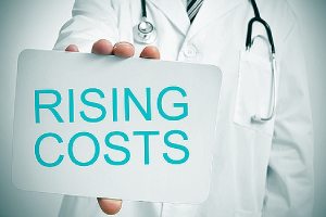 A doctor and rising cost written on a small placard depicting rising healthcare costs