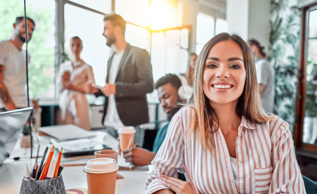 women happy in office with her Government Contractor Employee Benefits