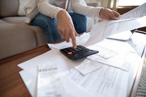 busy woman using calculator renter checking bills