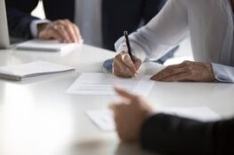 businesspeople signing nonprofit general liability insurance for company