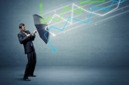 person with umbrella and colorful stock market arrows concept