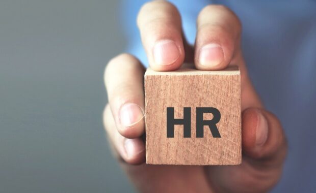 man holding HR word on wooden cube