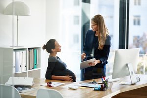 A female human resource executive and a pregnant employee having a conversation