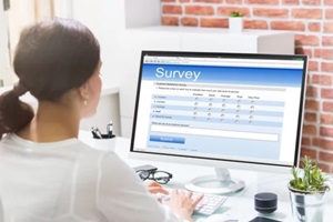 filling online survey form on computer at desk