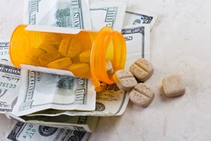 heathcare costs with pills bottle on dollar bills