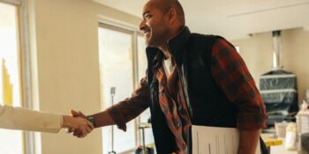 professional contractor shakes hands with happy homeowner for interior renovation project