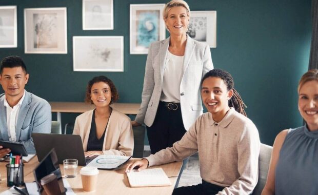 group of business people at desk with smile and confidence at meeting for employees in office
