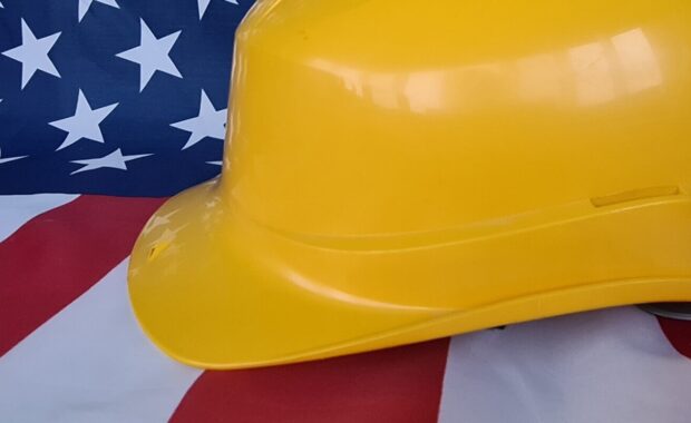 closeup of construction hard hat and USA flag